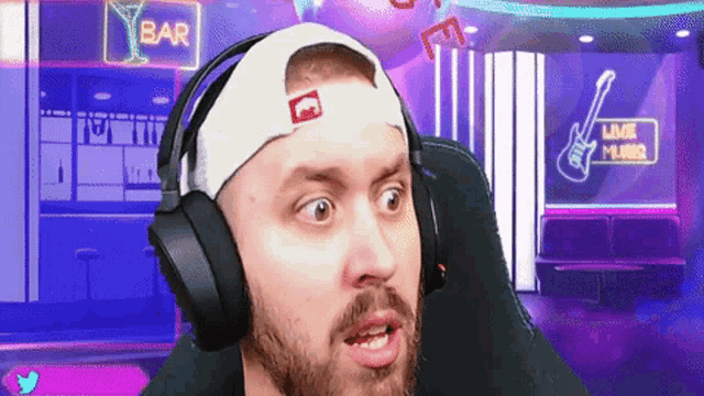 a man wearing headphones looks surprised in front of a bar sign
