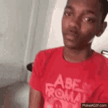 a young boy wearing a red shirt that says abe from