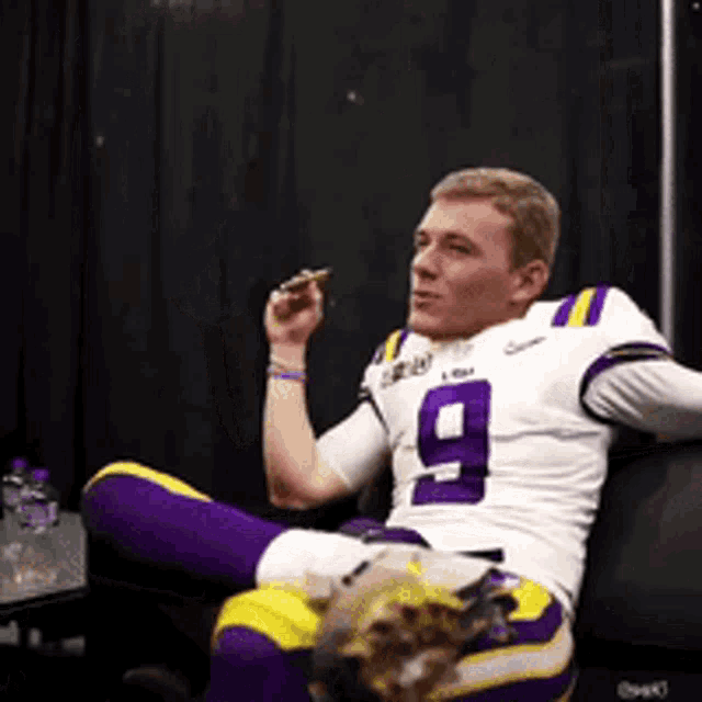 a man wearing a number 9 jersey is sitting on a couch