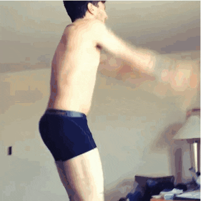 a shirtless man in black boxer shorts is jumping into the air