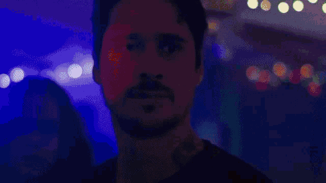a woman with long hair is standing in a dark room with blue lights .