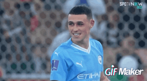 a soccer player in a blue etihad jersey is smiling