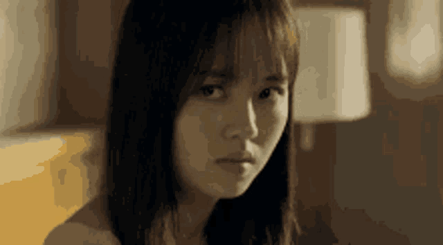 a close up of a woman 's face with a serious expression .