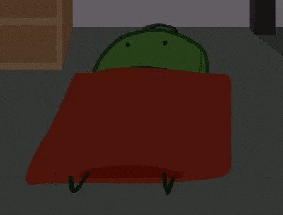 a green frog laying on a red blanket