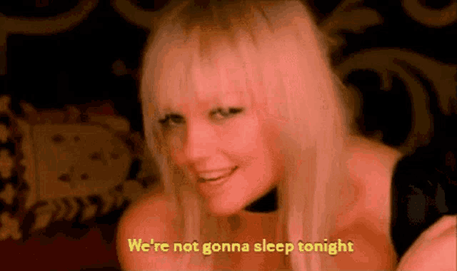 a woman is laying on a bed with the words `` we 're not gonna sleep tonight '' written on the bottom .