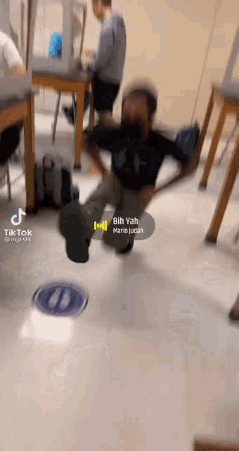 a man is sitting on the floor in a classroom with a mask on .