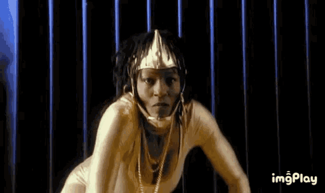 a woman is wearing a gold costume and a helmet .