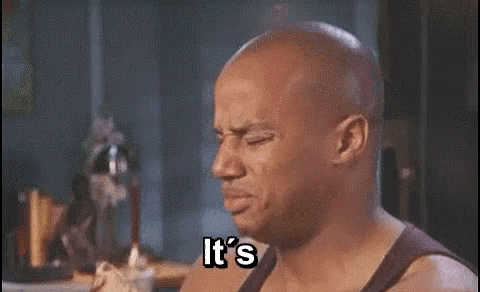 a bald man is eating a hot dog and saying it 's so hot .