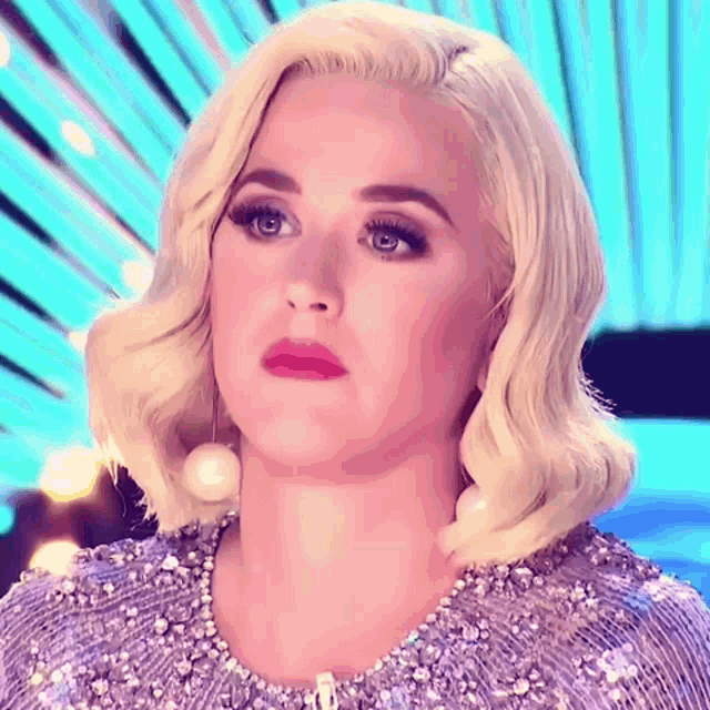 a woman with blonde hair is wearing a sequined top