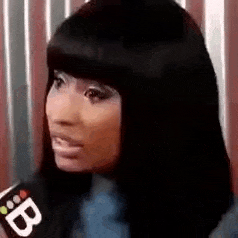 a woman with long black hair is talking into a microphone and making a funny face .