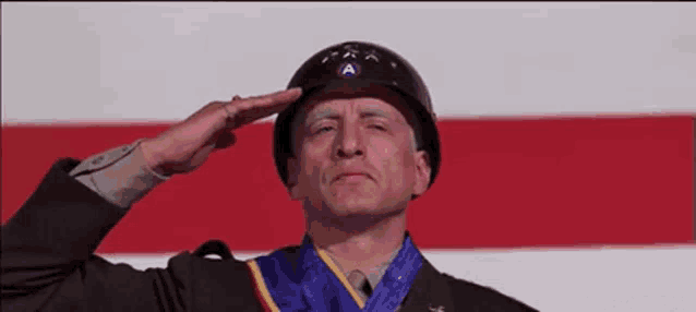 a man in a military uniform salutes in front of an american flag ..