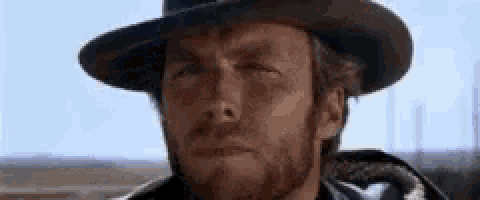 a man with a beard wearing a cowboy hat and a poncho .
