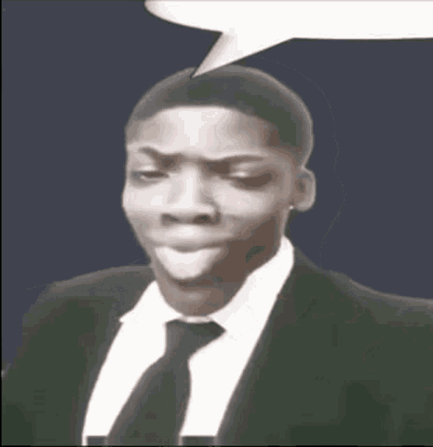a man in a suit and tie is making a funny face with a speech bubble above his head