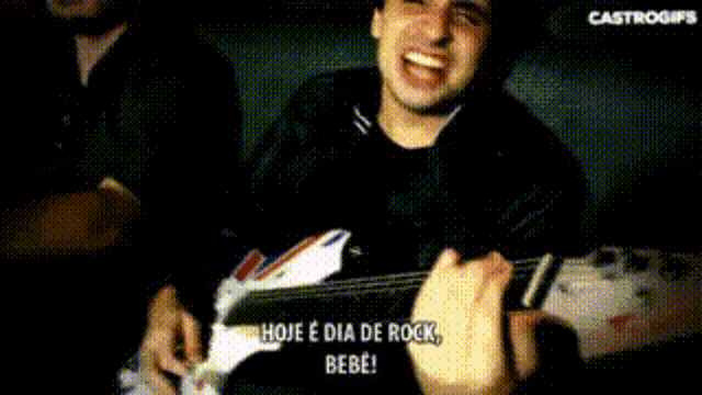 a man is playing a guitar with the words hoje e dia de rock bebe