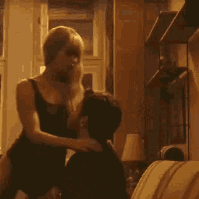 a man and a woman are having sex on a bed . the woman is wearing a black tank top .