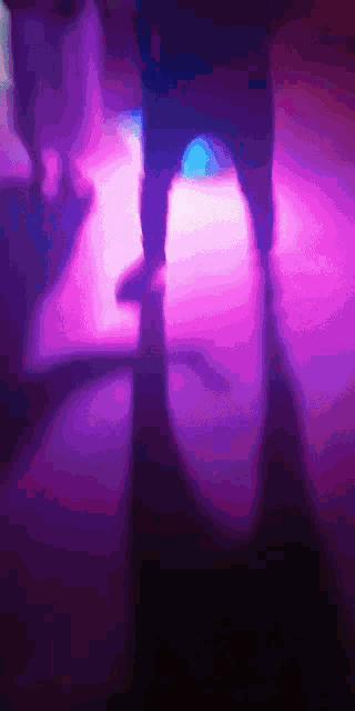 a person 's feet are visible in a blurry photo with purple lights behind them