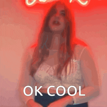 a woman is standing in front of a neon sign that says " ok cool "