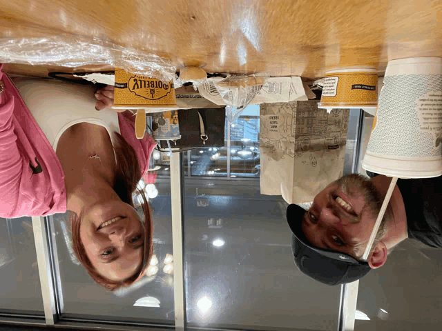 a man and a woman are sitting at a table with a container that says ' porterly ' on it