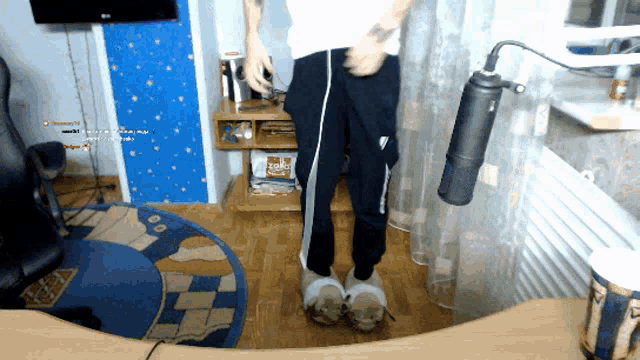 a man wearing a pair of slippers stands in front of a microphone in a room