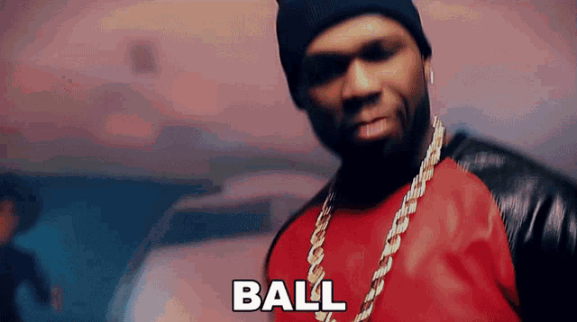 a man wearing a red shirt and a black beanie says the word ball