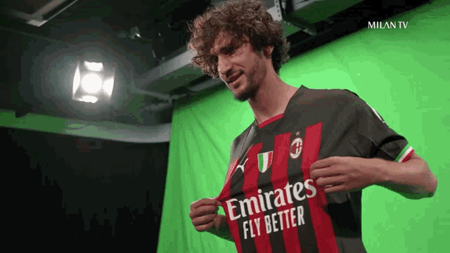 a man wearing an emirates fly better jersey