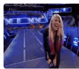 a woman with blonde hair is standing on a stage and laughing