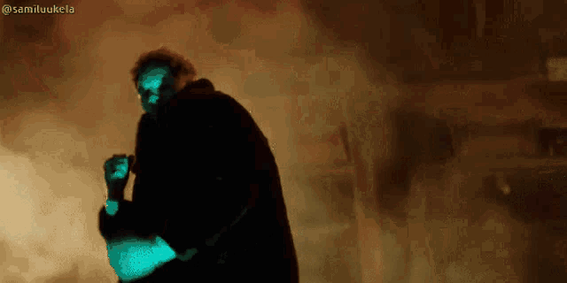 a man in a black coat is standing in a dark room with smoke coming out of it and the hashtag samiluukela