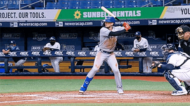 a baseball player getting ready to swing at a ball in front of a banner for sunbelt rentals
