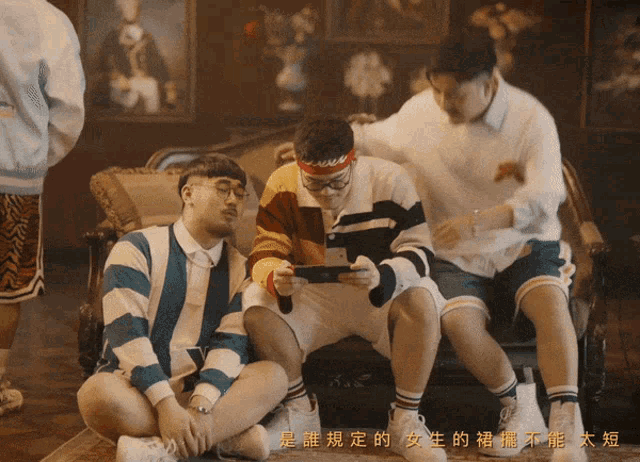 three men are sitting on a couch and one has a headband that says ' swag ' on it