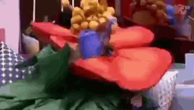 a red flower with a blue center is sitting on a table .