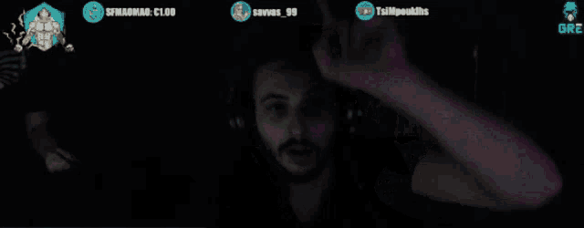 a man wearing headphones is dancing in front of a screen with a skull and the name tsimpouklis on it
