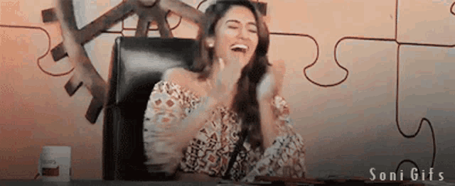 a woman is laughing in front of a puzzle wall and the words soni gifs are on the bottom
