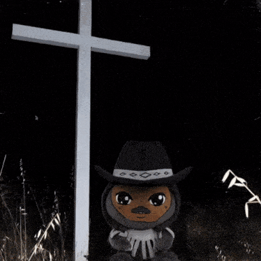 a stuffed animal with a long tongue sticking out is standing next to a cross