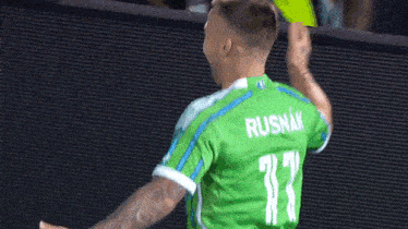 a soccer player wearing a green jersey with the name rush on it