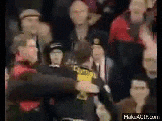 a blurry picture of a man holding a trophy in front of a crowd