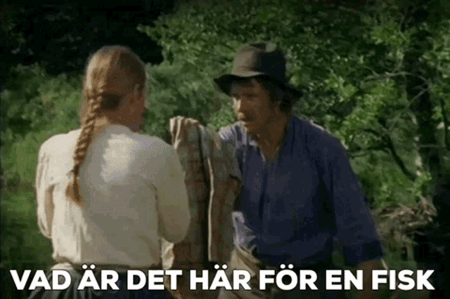 a man and a woman are standing next to each other with the words vad ar det har for en fisk written below them .