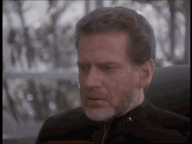 a man with a beard is sitting in a chair with his eyes closed