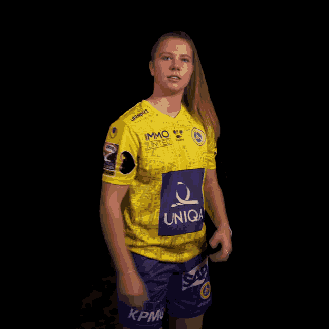 a woman wearing a yellow shirt that says uniqa on the front