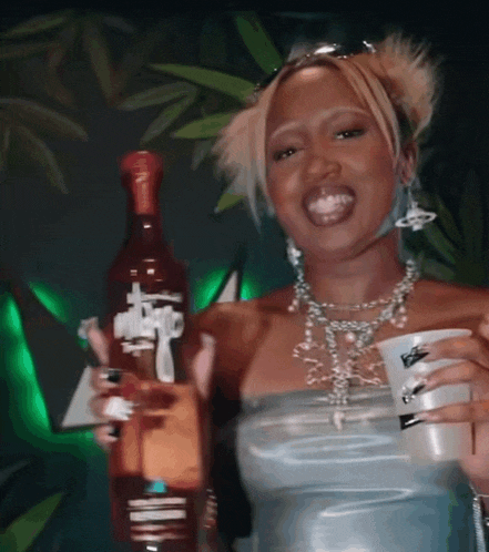 a woman in a blue dress is holding a bottle and a cup that says barbie