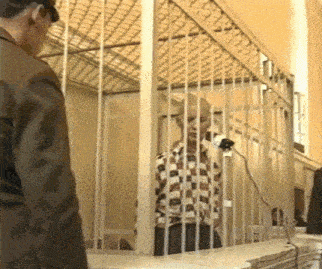 a man in a plaid shirt is in a jail cell