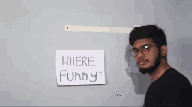 a man wearing glasses stands in front of a sign that says where funny