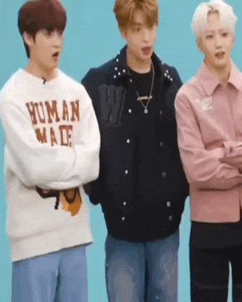 three young men are standing next to each other on a blue background .