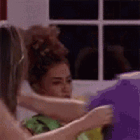 a woman is holding another woman 's hair in a bun in a room .