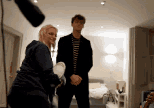 a man and a woman are standing in a room