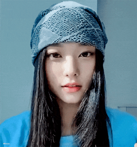 a woman wearing a blue hat and a blue shirt with the word design on the bottom