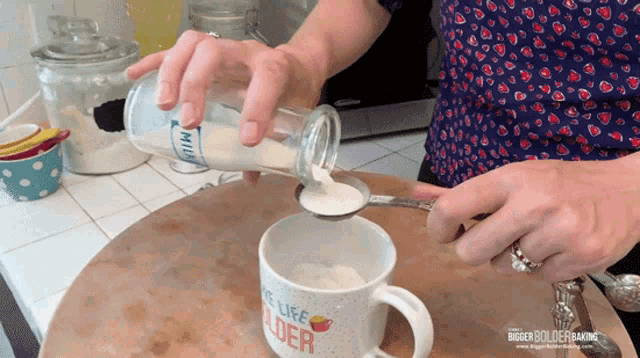 a woman is pouring milk into a cup that says life lover