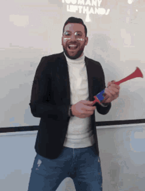 a man holding a trumpet in front of a whiteboard that says too many left hands