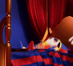 a stuffed animal in a jester costume is laying on a bed .