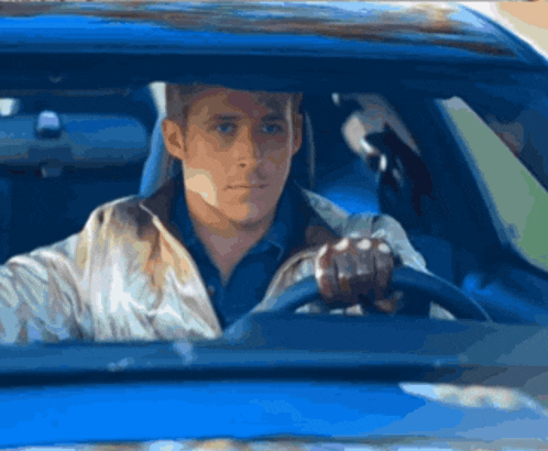 a man in a white jacket is driving a blue vehicle