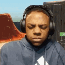 a man wearing headphones and a hoodie is making a face .